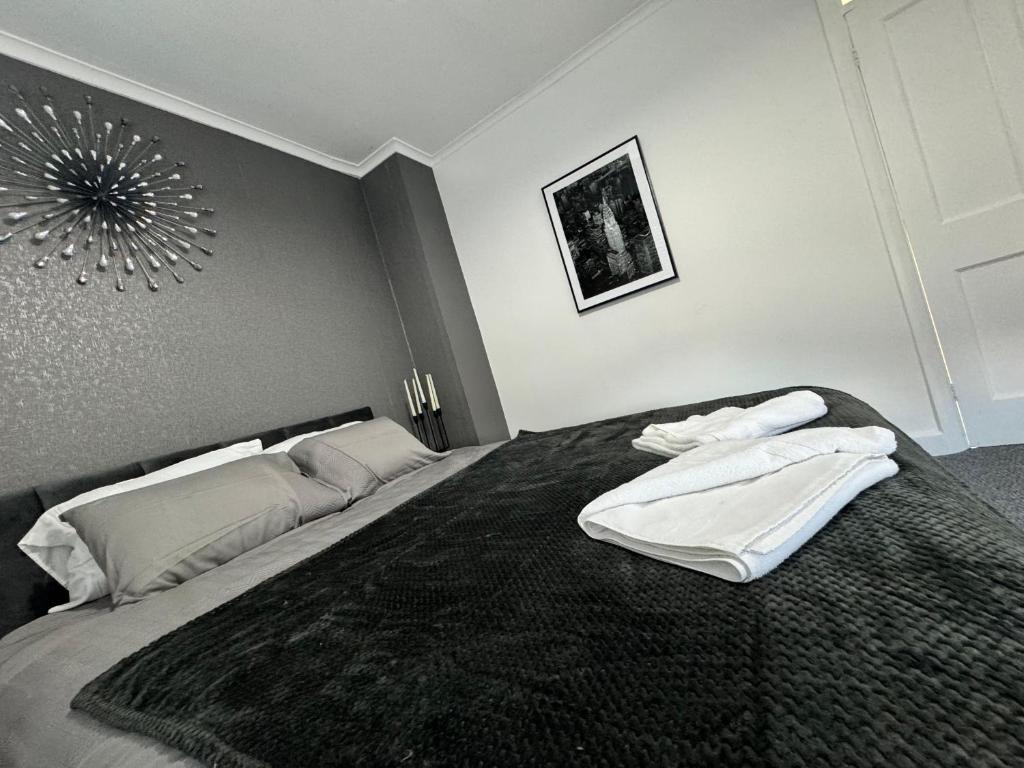 考文垂Home In Coventry的一间卧室配有一张床,上面有两条毛巾