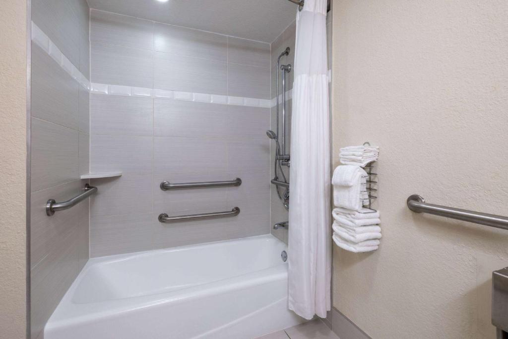 布卡拉顿博卡拉顿温德姆酒店的浴室配有浴缸、淋浴和毛巾。