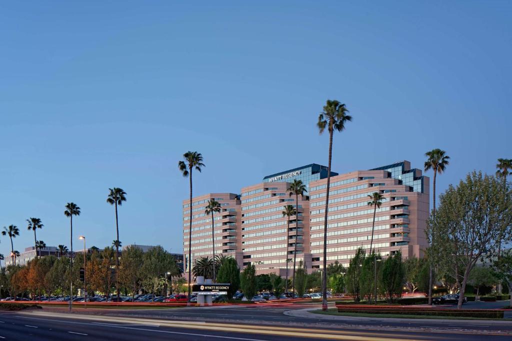 圣克拉拉圣克拉拉凯悦酒店的一条街道前方有棕榈树的大建筑