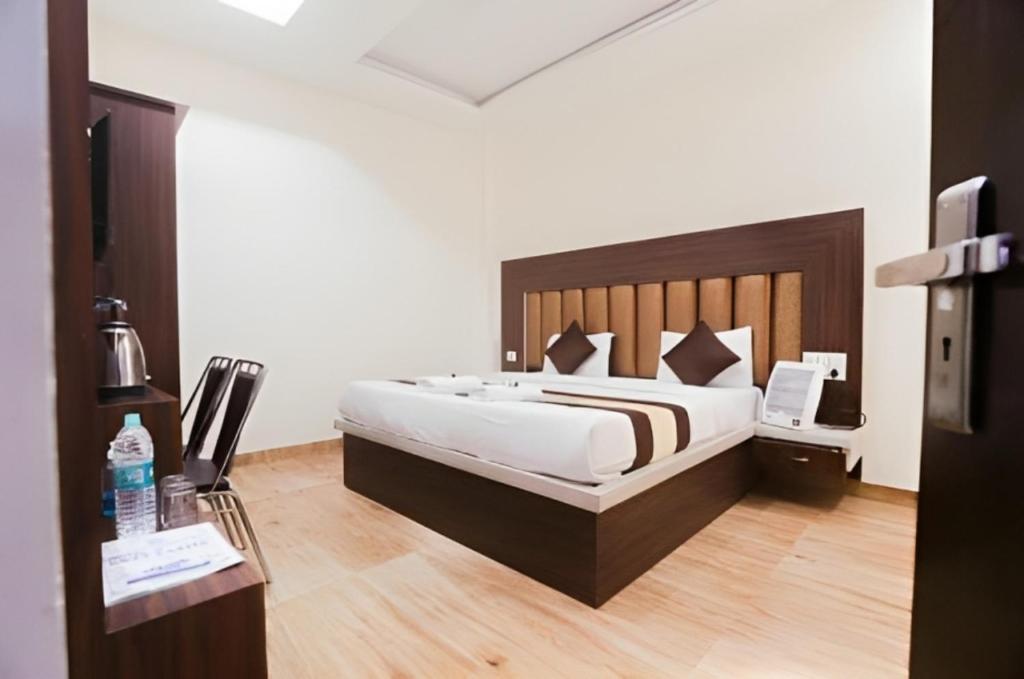 AyodhyaGoroomgo Hotel The Nirmala Palace Ayodhya-Near Ram Mandir的一间卧室配有一张大床和木制床头板