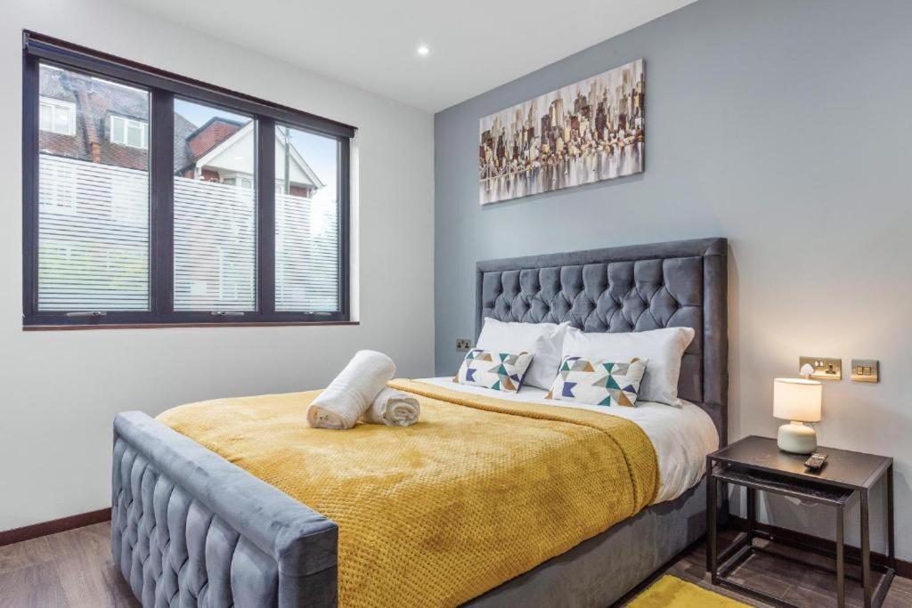 伦敦Serviced Golders Green Apartment near Camden London - 2的一间卧室配有一张带黄色毯子的大床