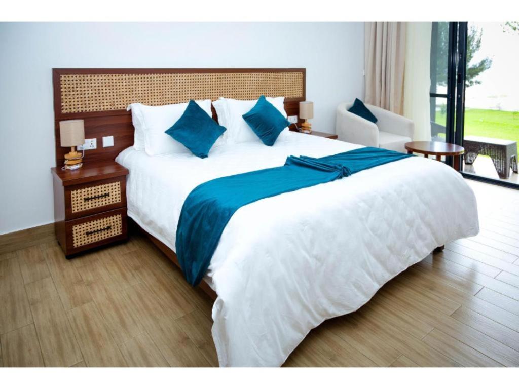 Eben Lake Kivu cottages and Villas的卧室配有一张大白色的蓝色床单