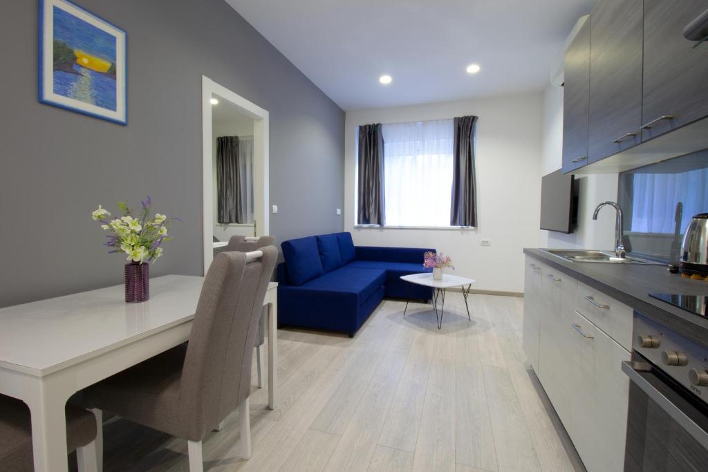斯普利特Split Urban Getaway的厨房以及带蓝色沙发的客厅。
