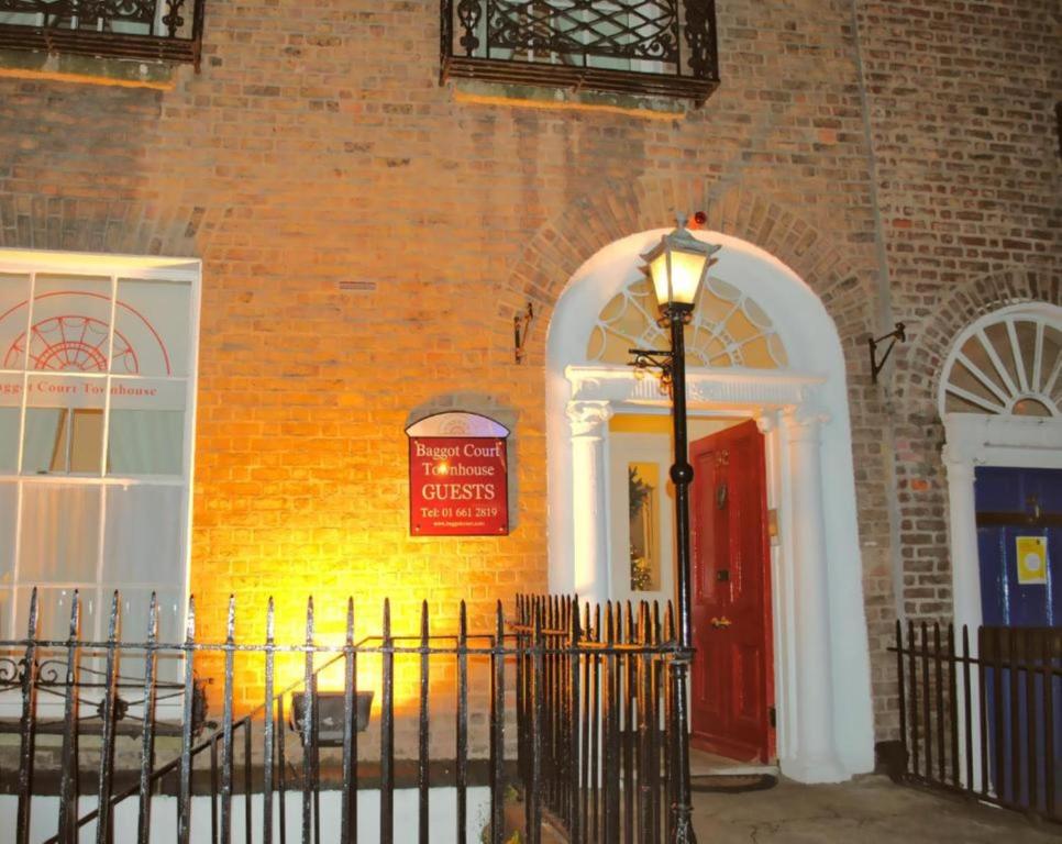 都柏林巴格特宫殿联排别墅酒店的红门和街灯的砖砌建筑