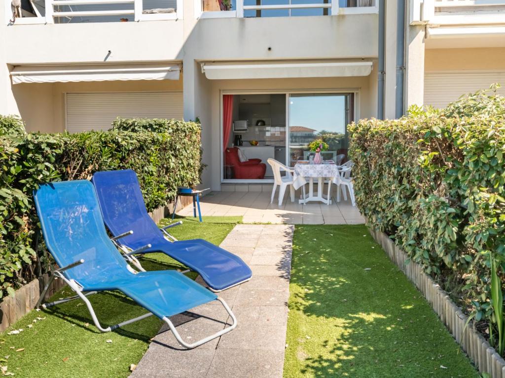 米尼赞海滩Apartment Les Pêcheurs-4 by Interhome的两把蓝色椅子坐在房子前面的草坪上
