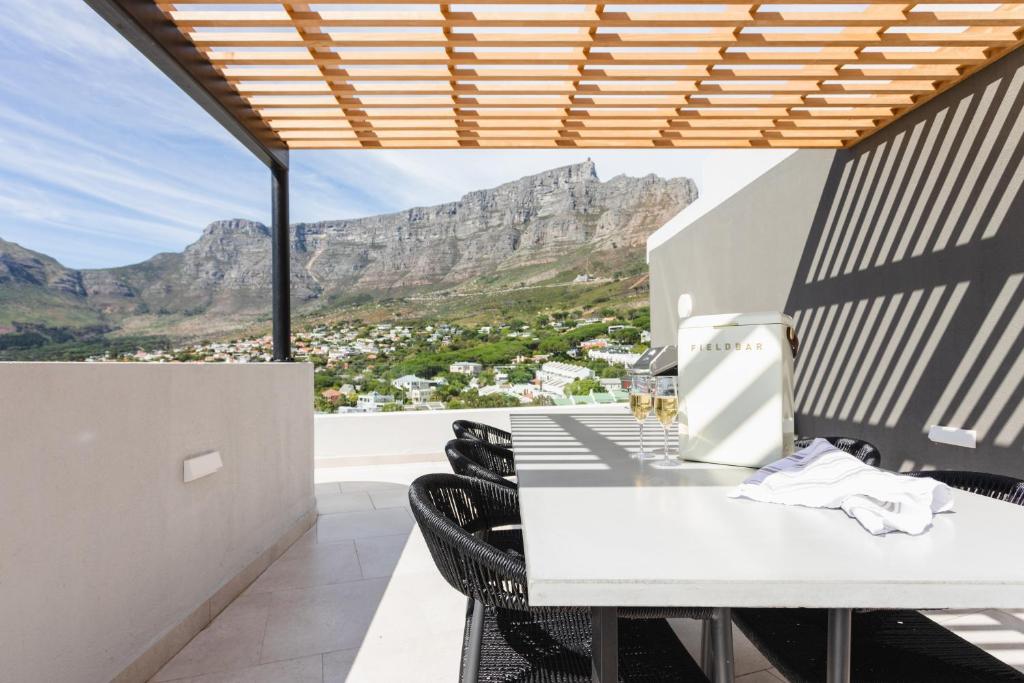 开普敦The View - Brand new Penthouse with private rooftop pool的厨房配有桌椅,背景为山脉