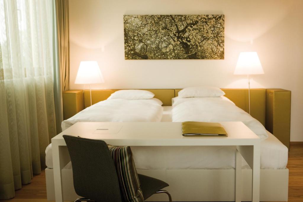 哈德时见酒店的一间卧室配有一张带桌子和两个枕头的床