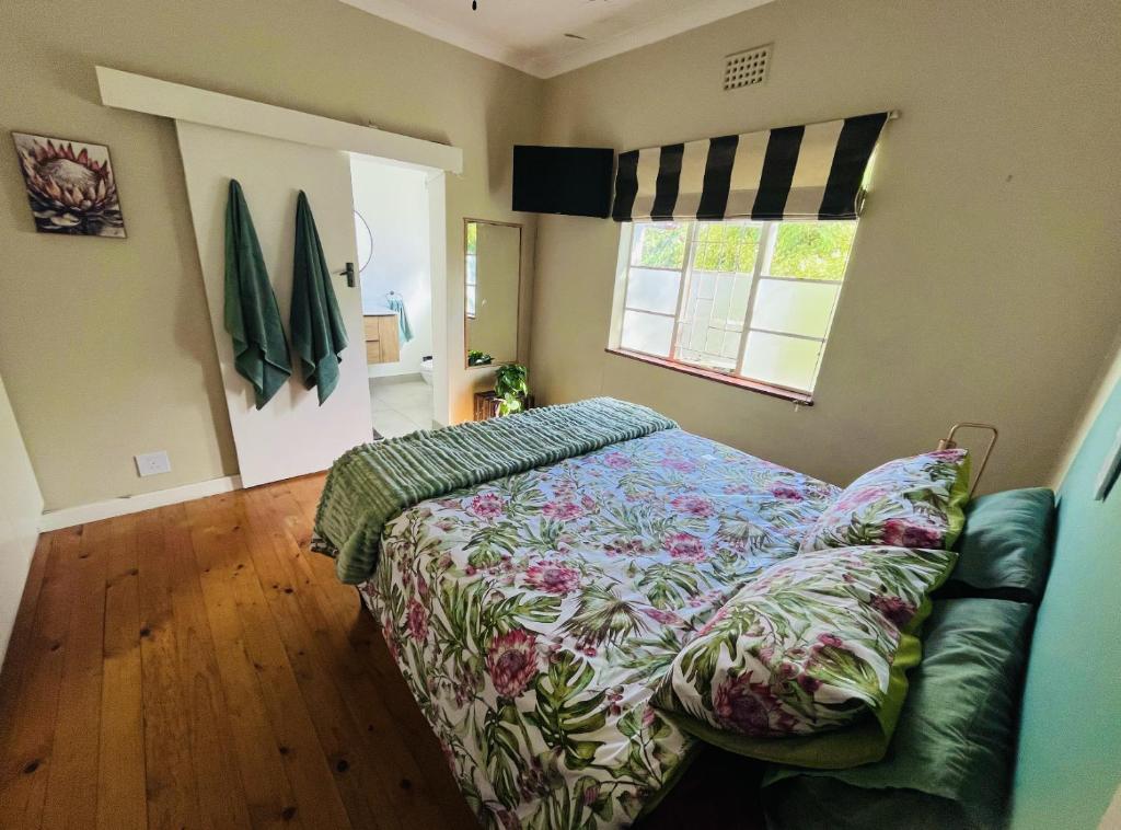 开普敦Rondebosch Cottage的一间卧室配有一张床和一张沙发