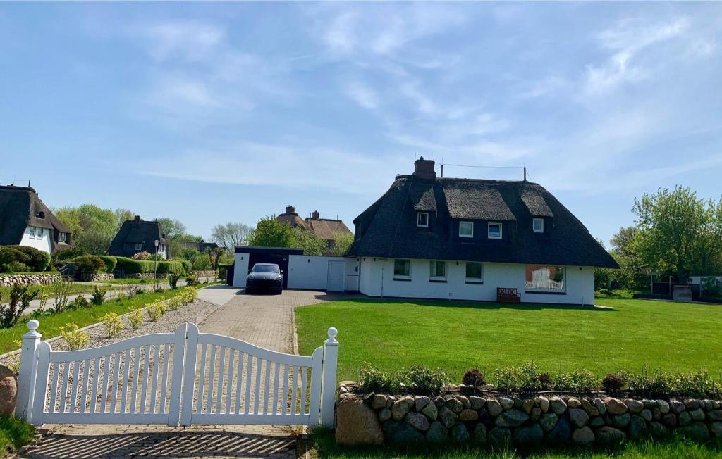 阿克斯姆Landhus-Sylt的白色的房子,有茅草屋顶和车道