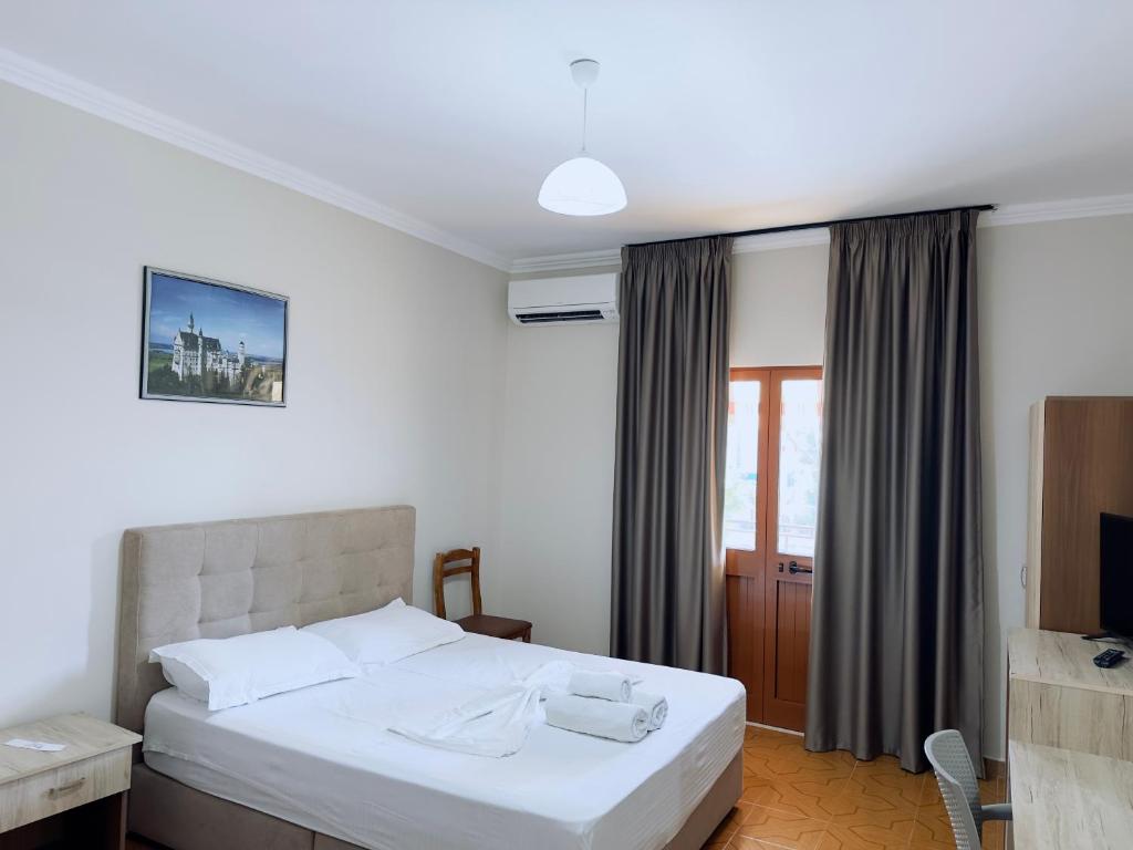 圣金Molla Hotel Restorant的卧室配有白色的床和电视。