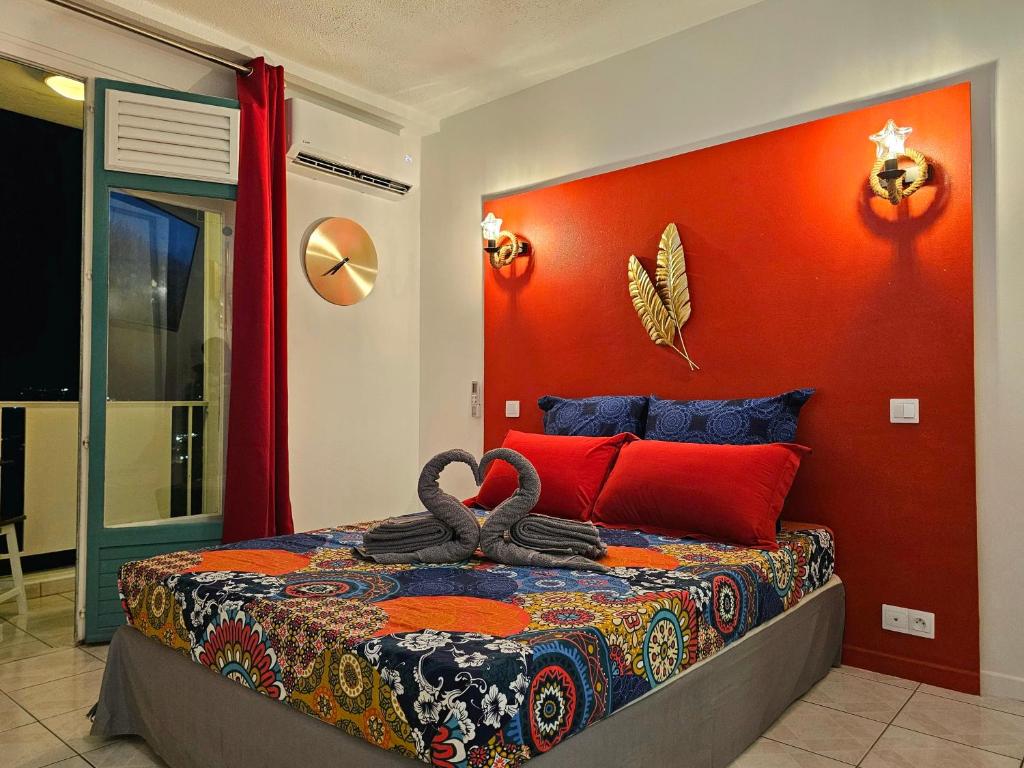 莱特鲁瓦西莱Sweet Crépuscule - Studio avec Vue Mer Imprenable & Piscine的一间卧室配有一张橙色墙壁的床