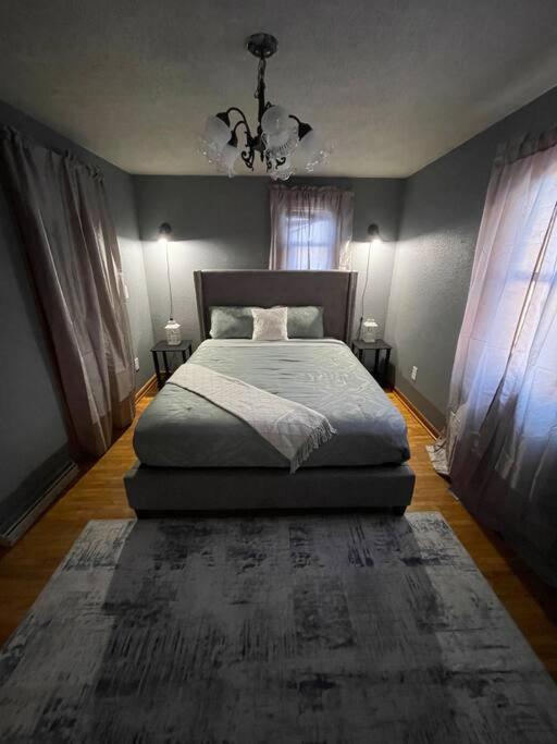 HibbingBeautiful Trailside Haven on the Edge of Town的一间卧室设有一张床和两个窗户。