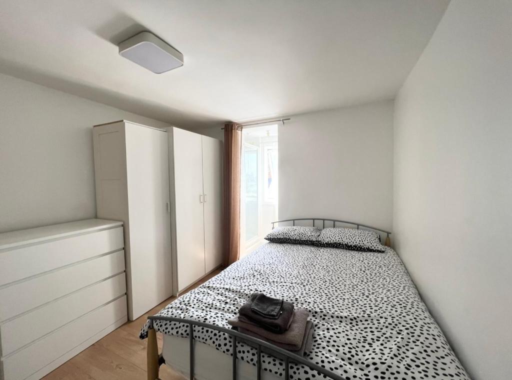 伦敦Cosy Studio - London的一间卧室配有一张带黑白色棉被的床
