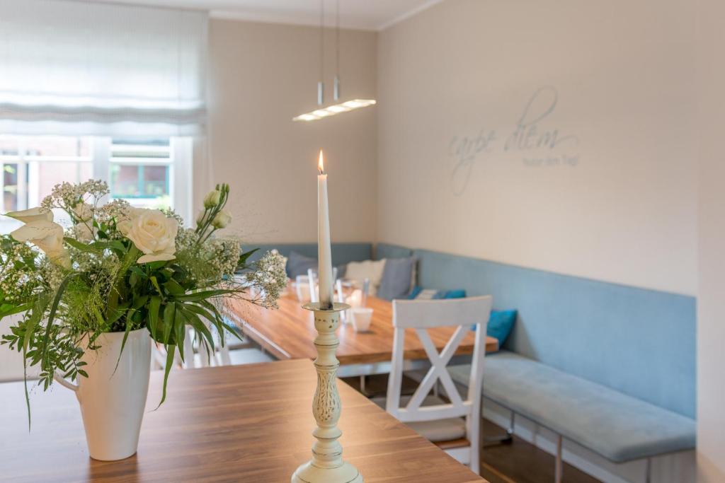 斯匹科罗格Spiekerhorst的用餐室配有带蜡烛和鲜花的桌子