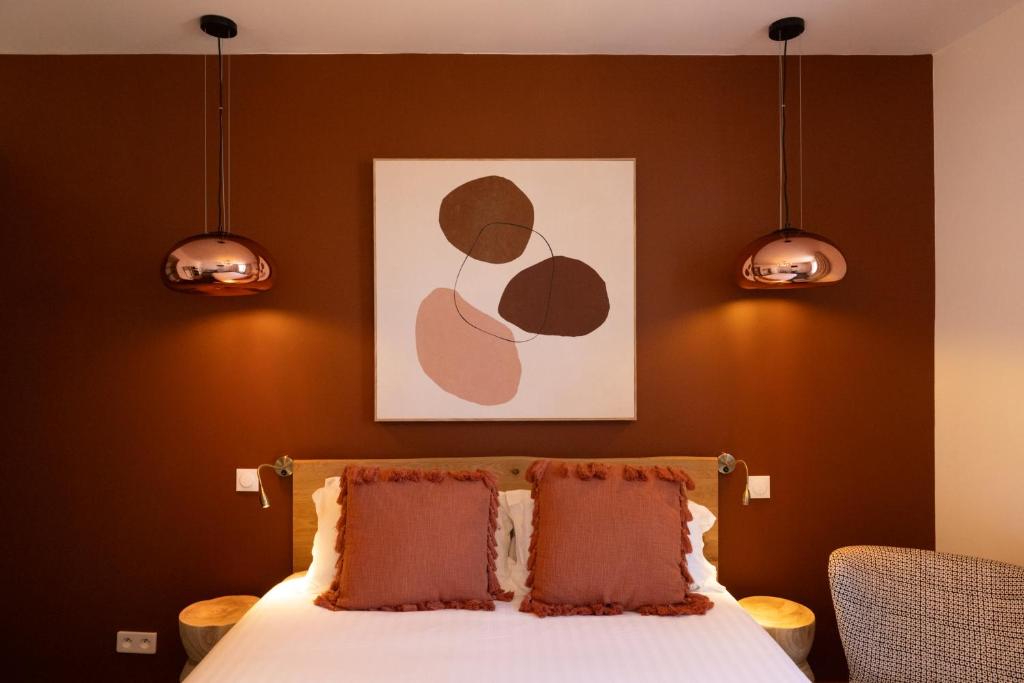 比亚里茨Hôtel Barnea的一间卧室配有带两个枕头的床和一幅画