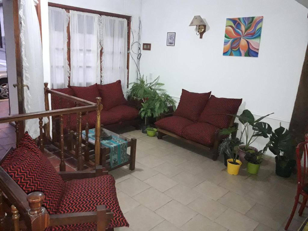 米娜克拉韦罗La Posada del Rey的客厅配有红色沙发和植物