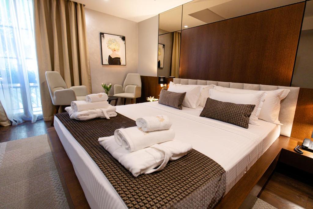 地拉那Hotel Sokrati的酒店客房带一张大床,带毛巾