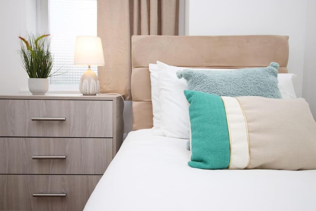 布里斯托Homely 2 Bedroom Apartment in Bristol for 5 Guests的一间卧室配有带枕头和床头柜的床