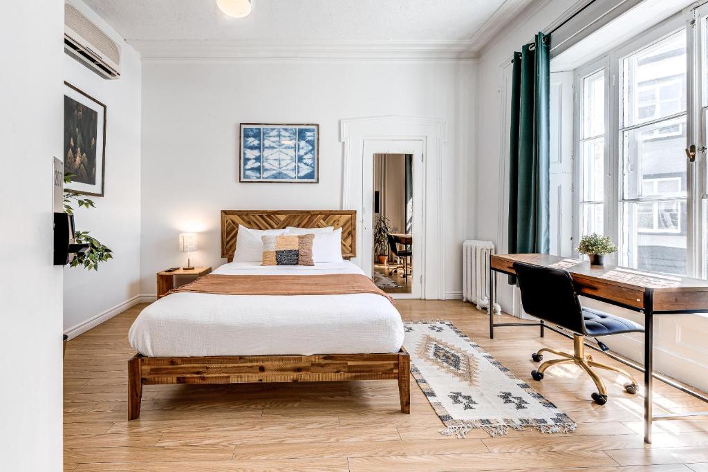魁北克市Hôtel Automatisé Manoir des Remparts的一间卧室配有一张床和一张书桌