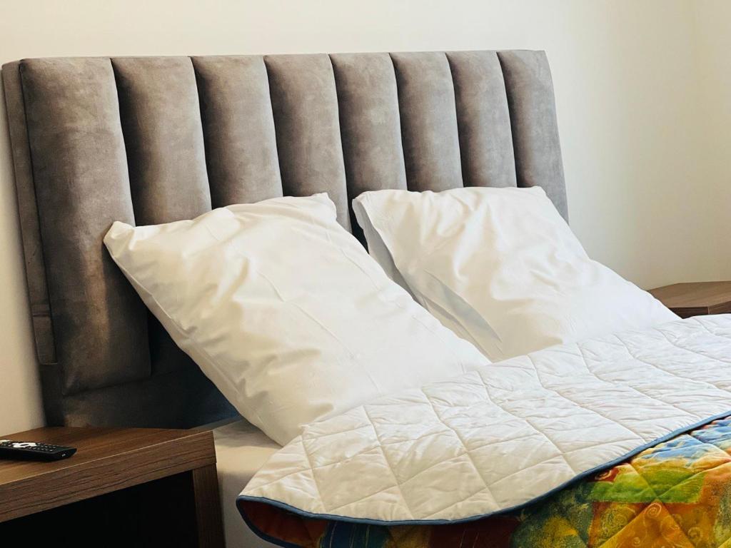 巴纽Auberge de Bagneux的床上铺有白色枕头的床
