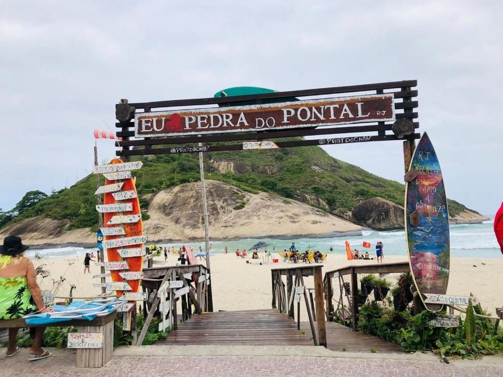 里约热内卢lindo apartamento no recreio bem pertinho da praia的海滩上的码头上带有冲浪板的标志