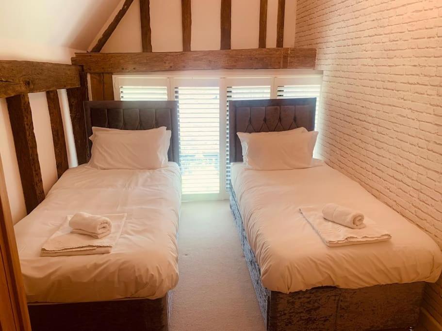 Hatfield Broad OakBARN: Sleeps 6, Stansted 12 mins的带窗户的客房内设有两张单人床。
