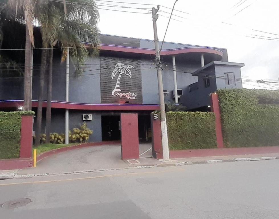 CarapicuíbaHotel Coqueiros 6的旁边是一座棕榈树的建筑