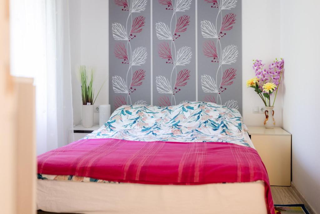 斯诺基Apartman Milka的一间卧室配有一张带粉红色棉被的床