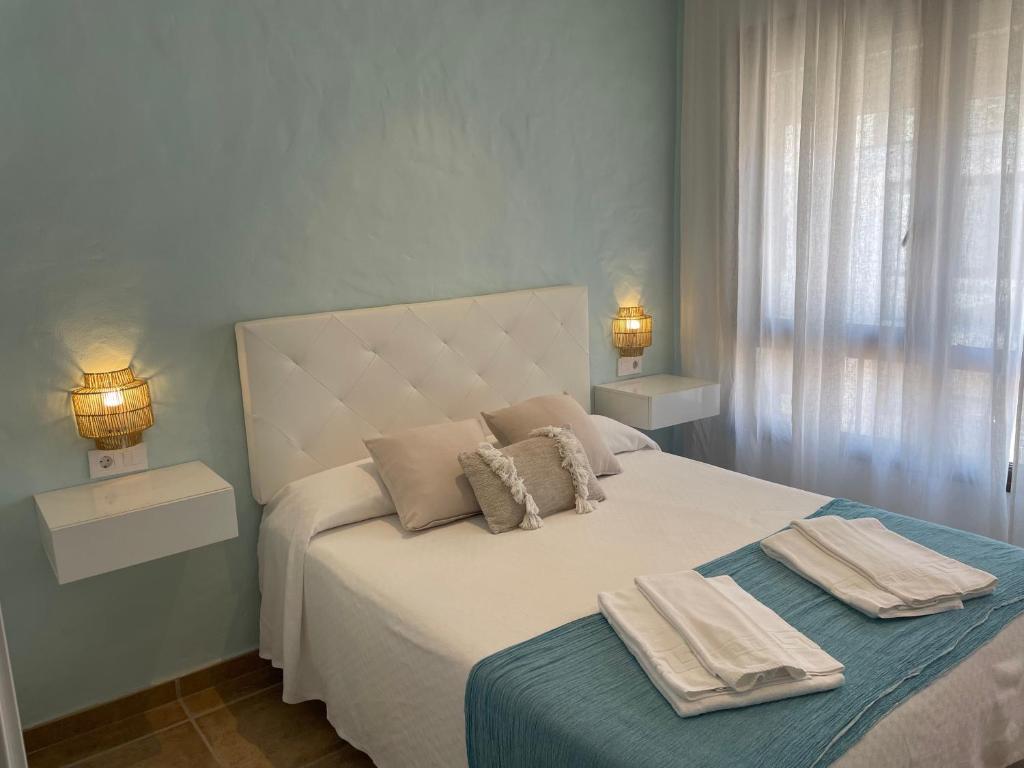 萨阿拉德洛斯阿图内斯El Escondido de Zahara的一间卧室配有一张床,上面有两条毛巾
