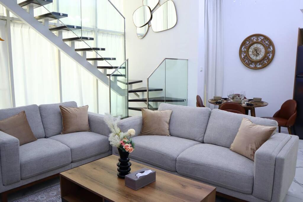 阿布扎比MasdarCity Bliss 2BR apartment的客厅配有沙发和桌子