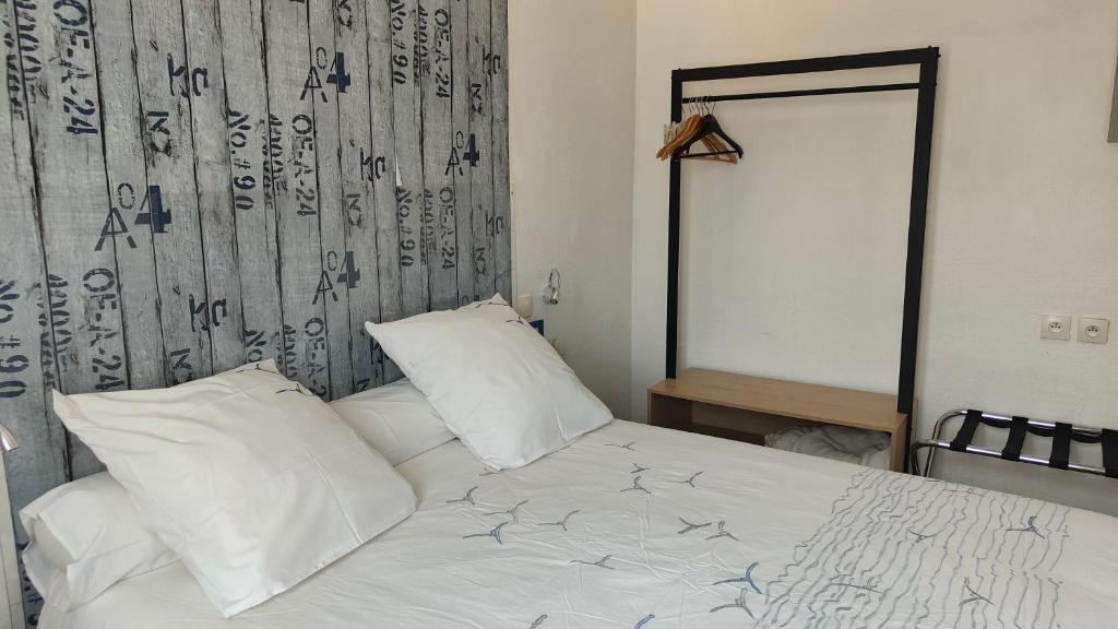 图尔圣让酒店的一张带白色床单和枕头的床