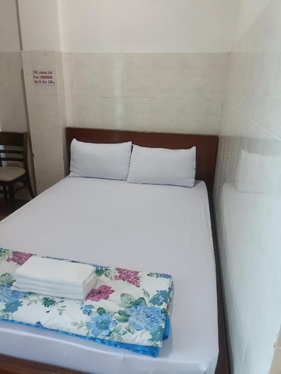 胡志明市Hotel phương linh 364 phạm hùng的一张位于小房间的床,配有白色的床上用品