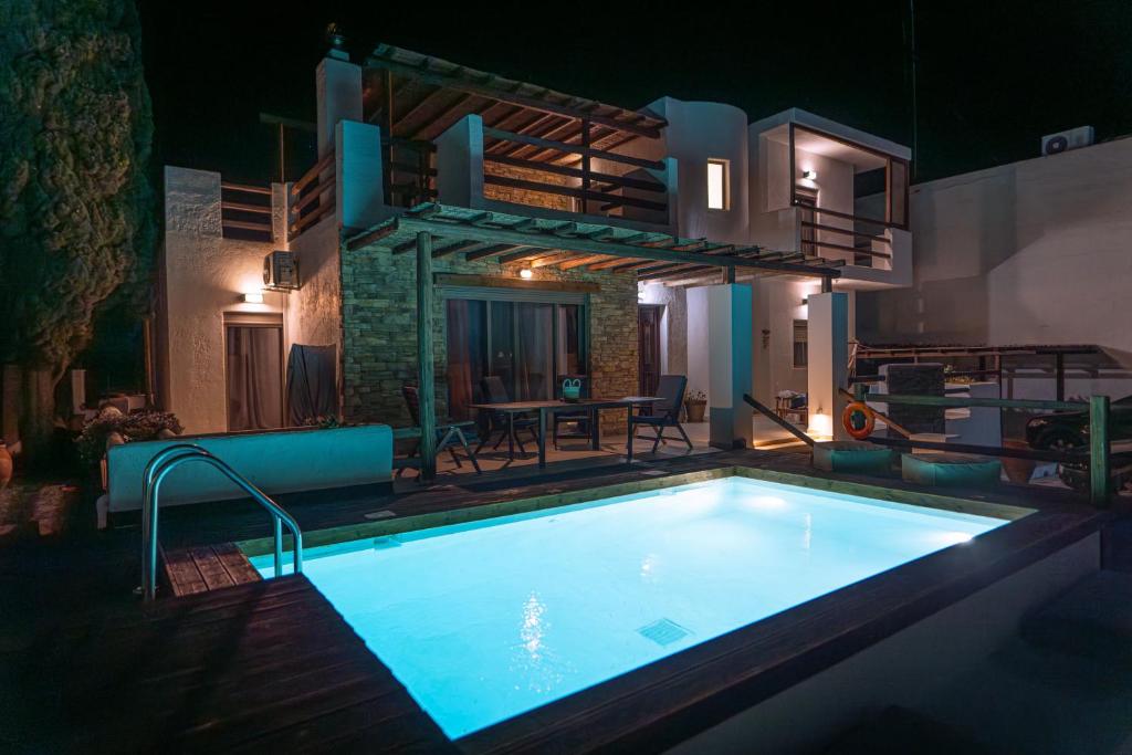 卡利诺岛Apollonas & Sibylla Villa的夜间在房子前面的游泳池