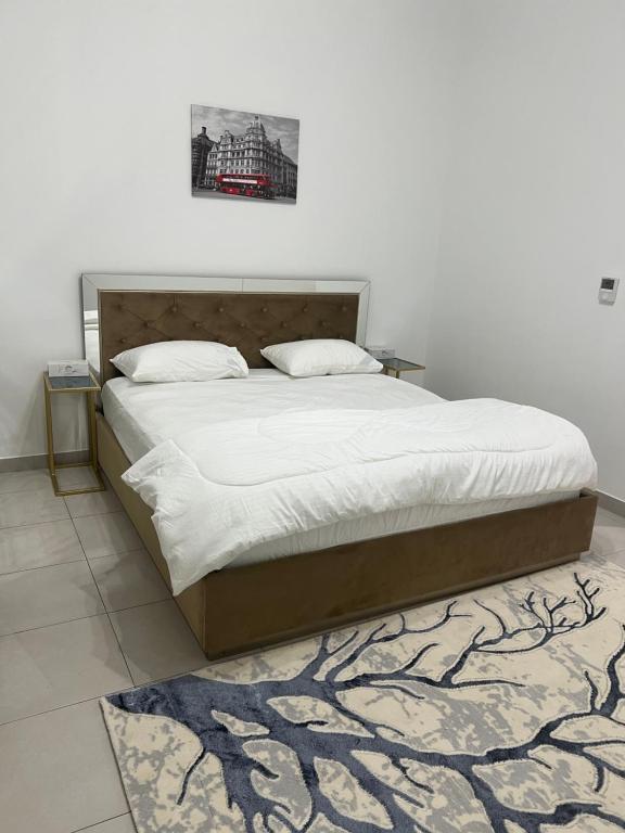 迪拜Dubai Entire Serviced Room Unit Excellence的卧室配有一张带白色床单和地毯的大床。