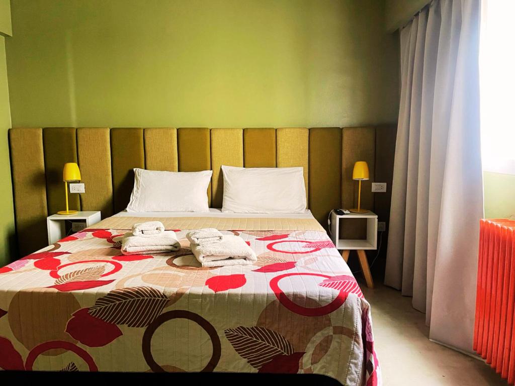 门多萨Hotel Windsor Mendoza的一间卧室配有一张床,上面有两条毛巾