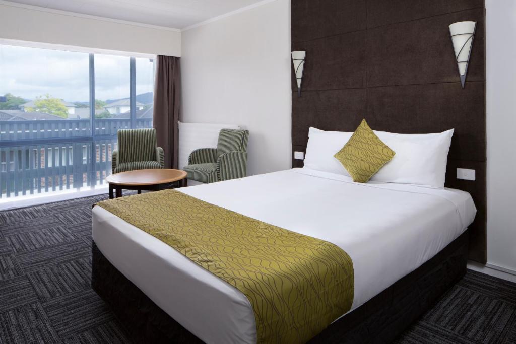 罗托鲁瓦Marsden Stay Rotorua的酒店客房设有一张大床和一个阳台。