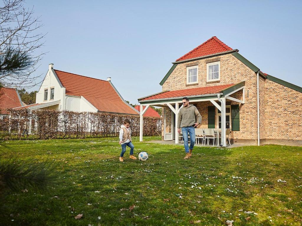 罗赫尔Spledid villa with sauna and whirlpool in Limburg的玩足球的男人和孩子