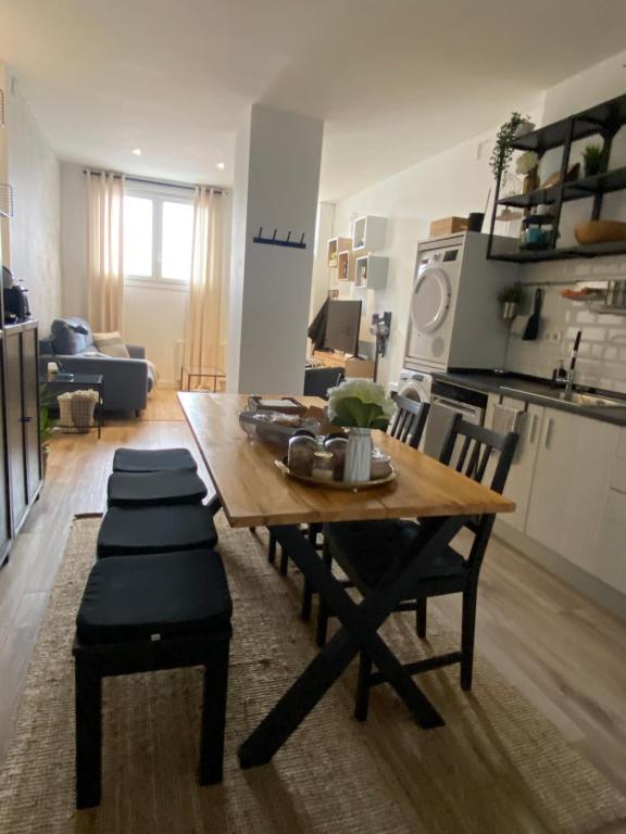 拉萨尔特Apartamento Donosti Aldea的厨房以及带木桌和椅子的客厅。