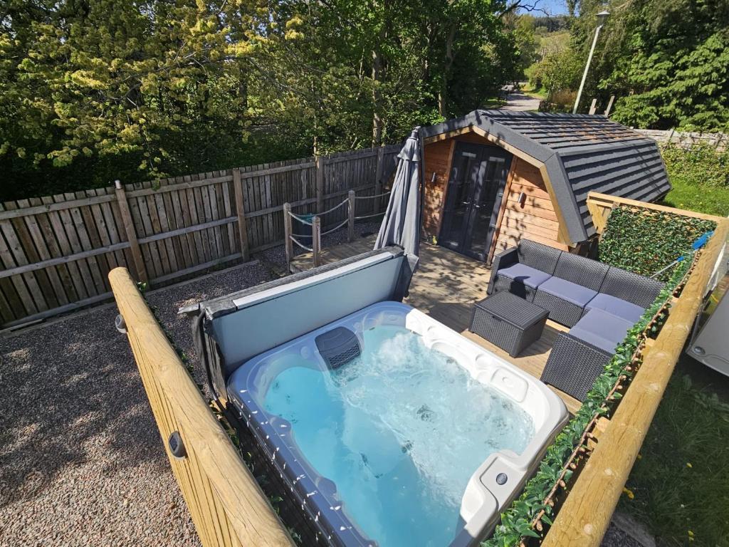 威廉堡Morvan Pod & Hot tub的后院内带狗屋的大型热水浴池