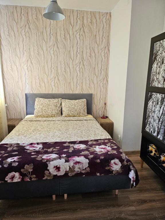 格但斯克Apartament Góralska的一间卧室,床上放着鲜花