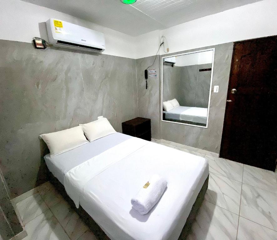 巴兰基亚Hotel Rancho Grande的卧室配有白色的床和毛巾