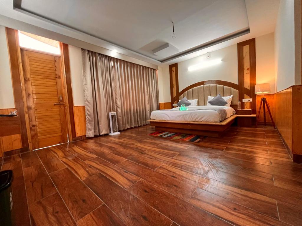 朱纳格特Raghav Bro Stays的一间卧室配有一张床,铺有木地板