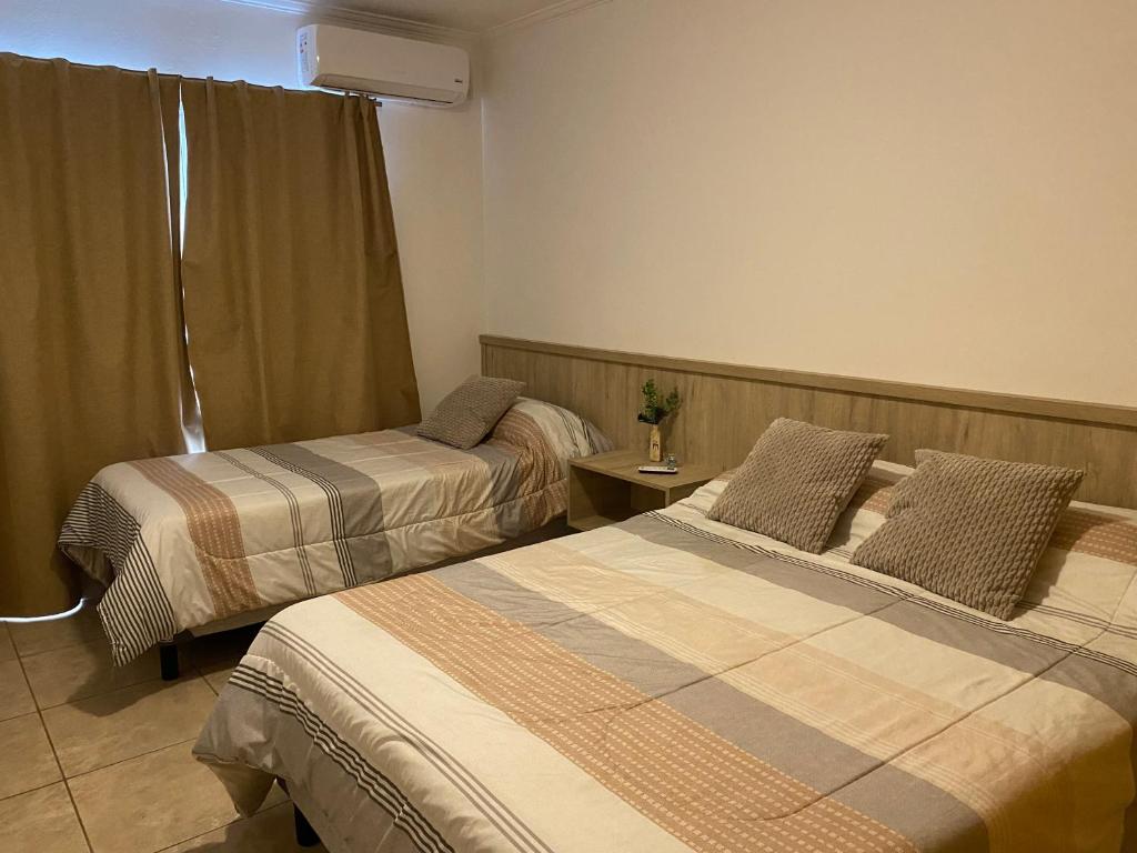 圣罗莎Complejo Pampa 2的酒店客房设有两张床和窗户。