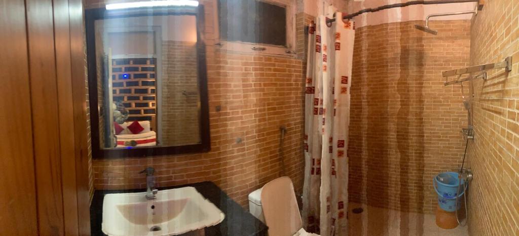 朱纳格特Swastik Royal Lodge的一间带水槽、卫生间和镜子的浴室