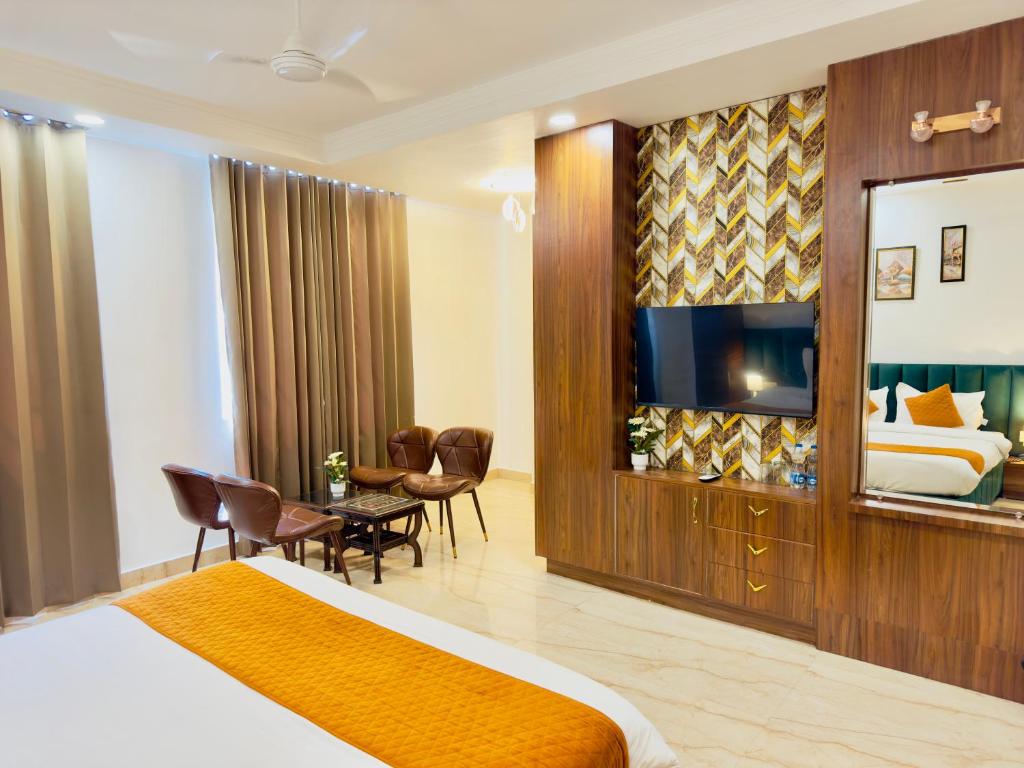 贾姆讷格尔Sanklap Hotel的一间酒店客房,配有一张床和一台电视