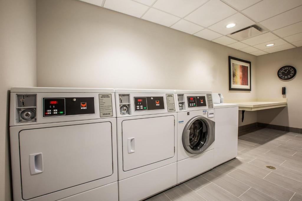 希尔斯伯勒Holiday Inn Portland West - Hillsboro, an IHG hotel的洗衣房配有3台洗衣机和1个柜台