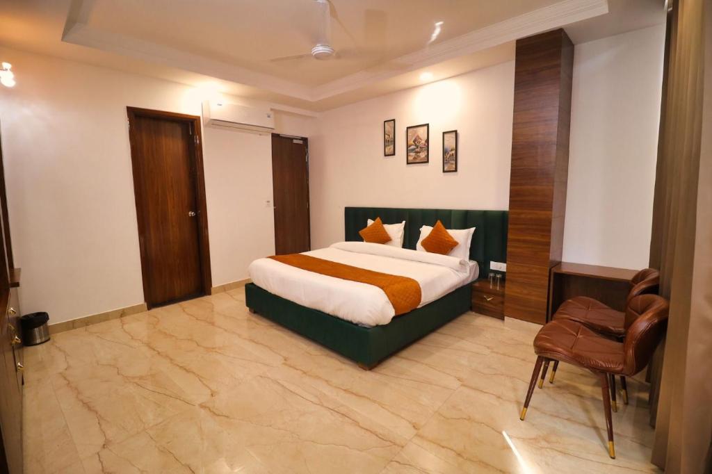 贾姆讷格尔Sandhu Lodge的配有一张床和一把椅子的酒店客房