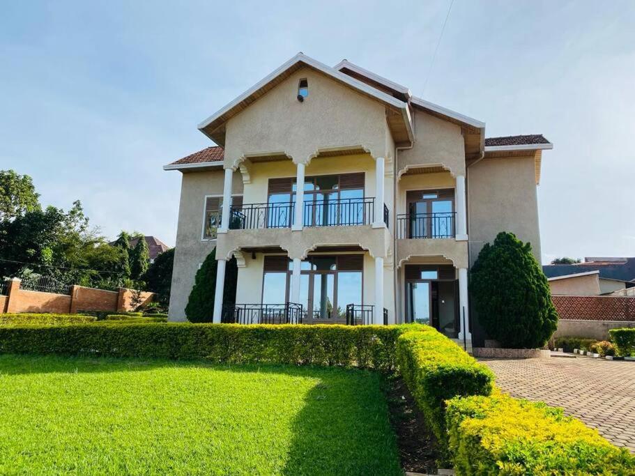 基加利Quiet and Spacious Hidden Gem in Kigali with Breathtaking Views right by the Airport的前面有 ⁇ 形的大房子