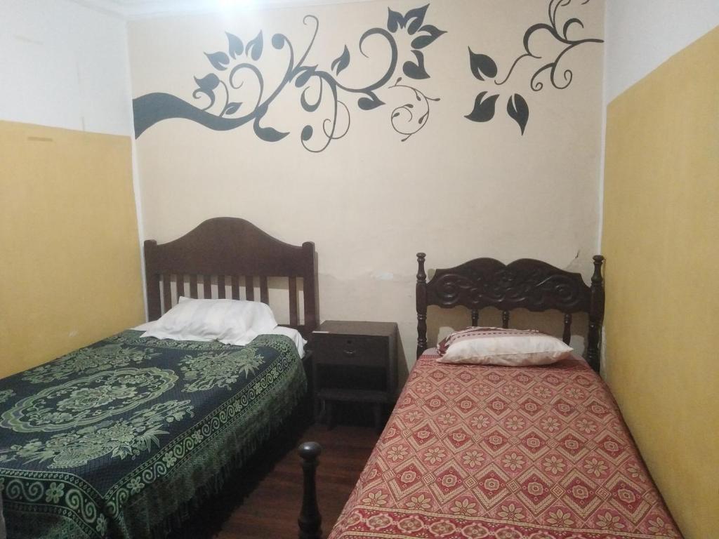 苏克雷Alojamiento constitucional的卧室配有两张床,墙上有标志