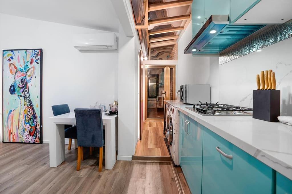 墨尔本Prime Modern Brilliance with Prahran Convenience的厨房配有蓝色橱柜和白色台面